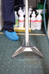 A Carpet Technician Cleaning With a Vacuum